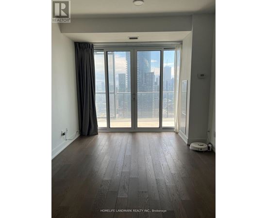 A room with a large window and wooden flooring.