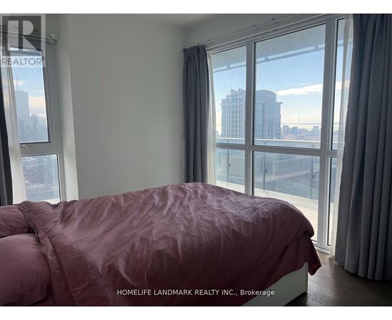 A bedroom with a large bed and a view of the city.