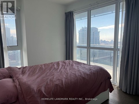 A bedroom with a large bed and a view of the city.