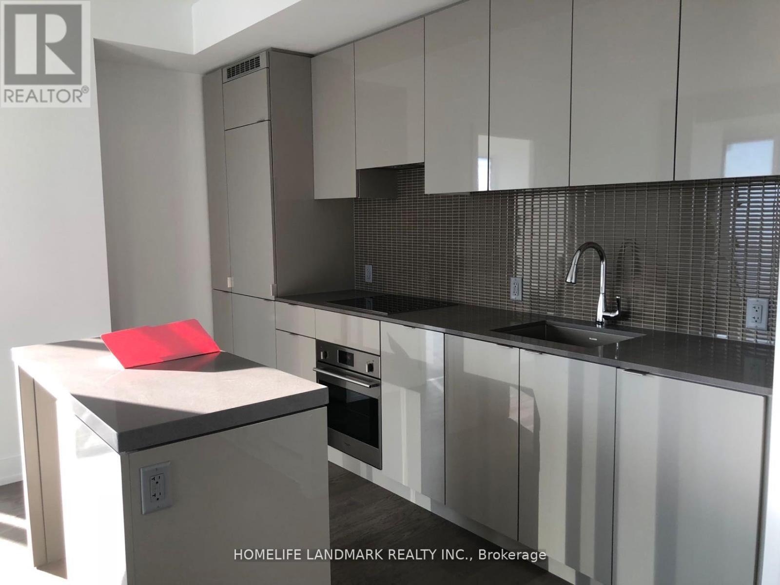 A modern kitchen with a red towel on the counter.