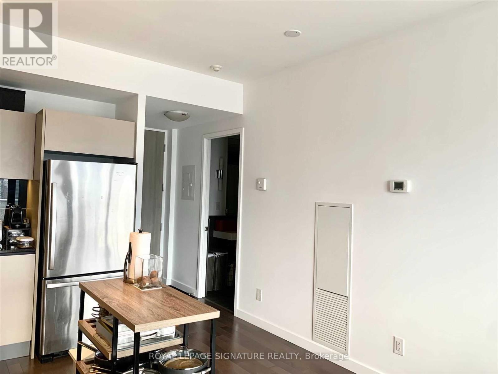 A modern kitchen with a table and a refrigerator.