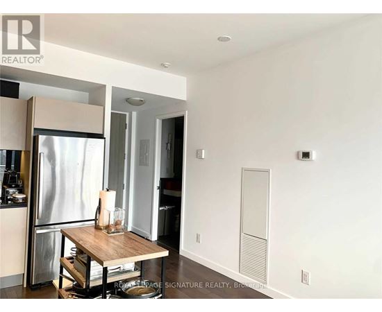 A modern kitchen with a table and a refrigerator.