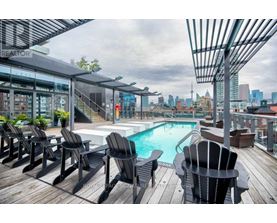 A pool area with lounge chairs and a hot tub.