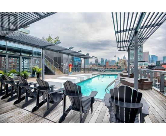 A pool area with lounge chairs and a hot tub.
