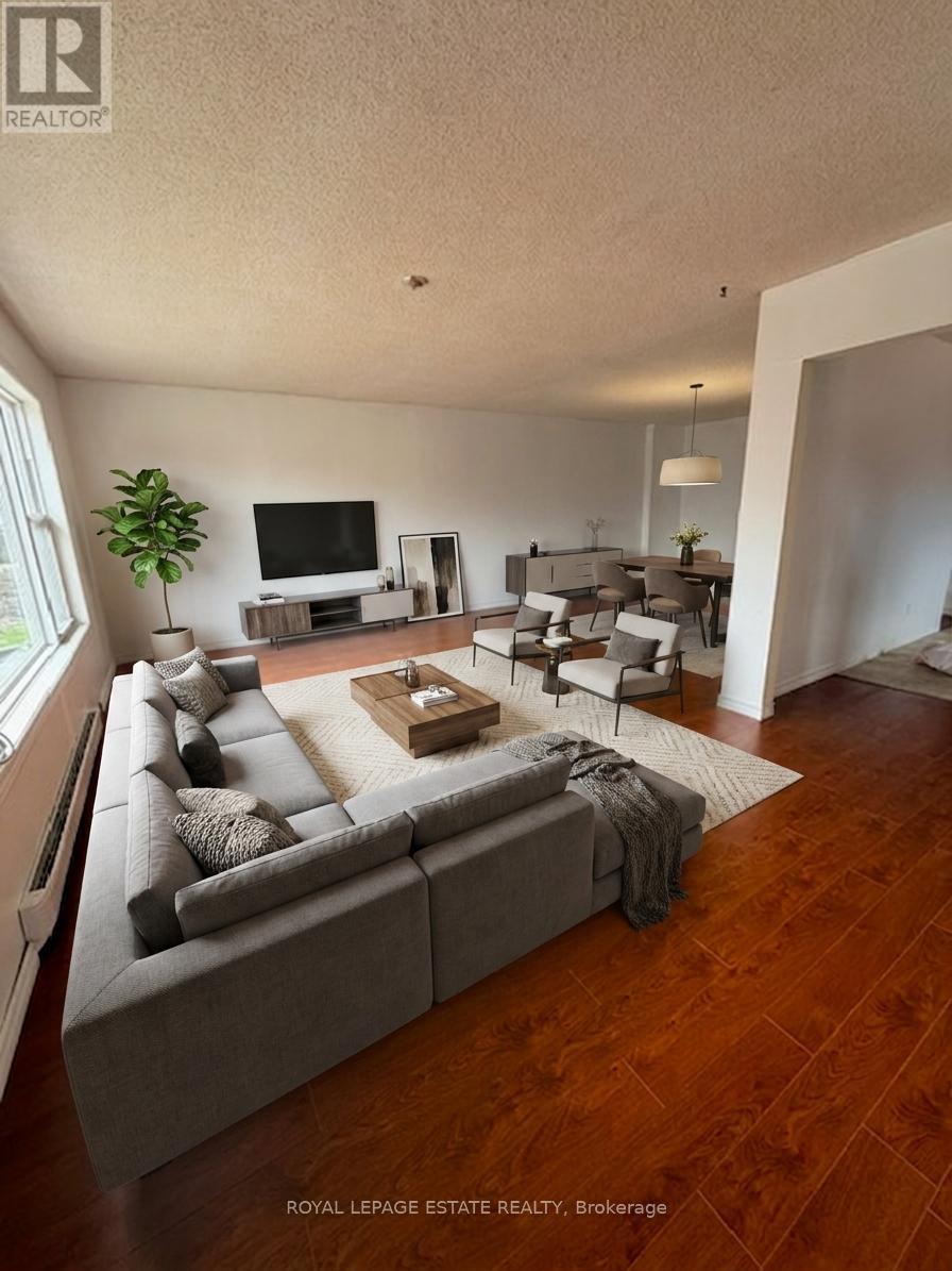 A living room with a grey couch and a wooden floor.