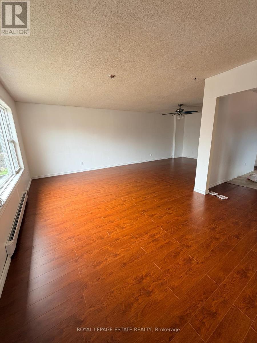A room with wooden flooring and a ceiling fan.