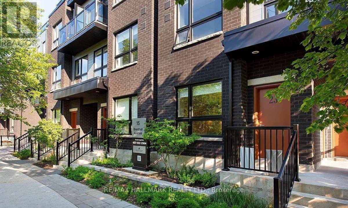 A modern brick building with a balcony and a black railing.