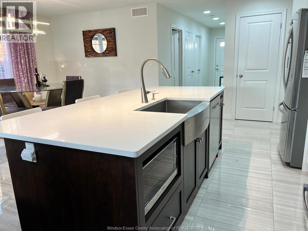 A kitchen with a white counter top and black cabinets.