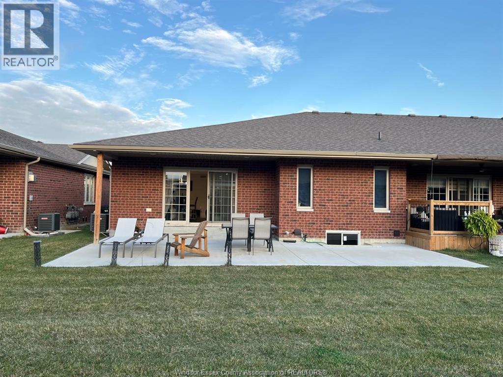 A house with a lawn and patio furniture is for sale.