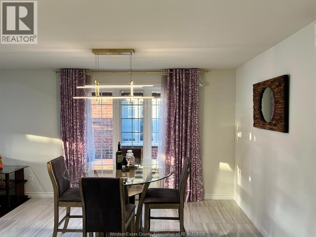 A dining room with a table set for two and a window with curtains.
