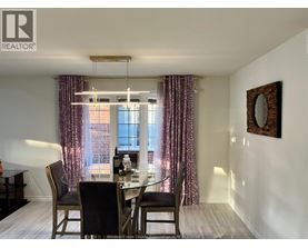 A dining room with a table set for two and a window with curtains.