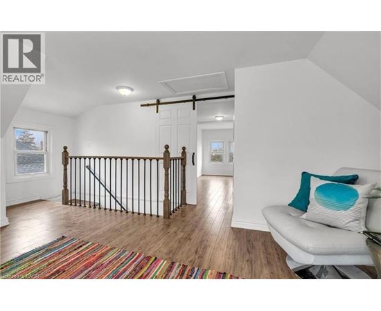 A living room with a white couch and a colorful rug.