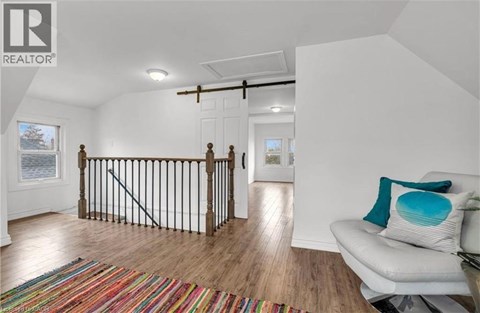 A living room with a white couch and a colorful rug.