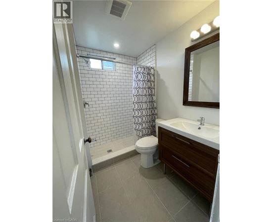 A bathroom with a toilet, sink, and shower.