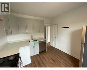 A kitchen with white cabinets and a black stove top.
