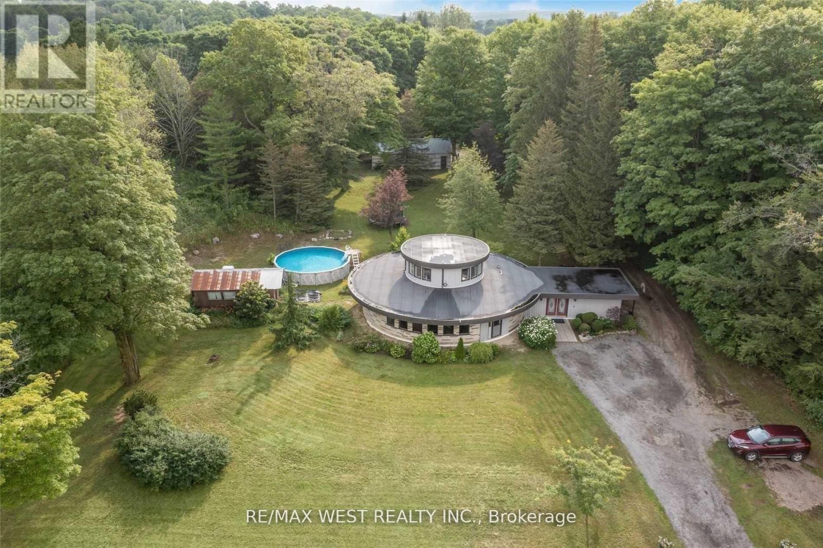 A large house with a circular driveway and a pool in the backyard.