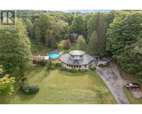 A large house with a circular driveway and a pool in the backyard.
