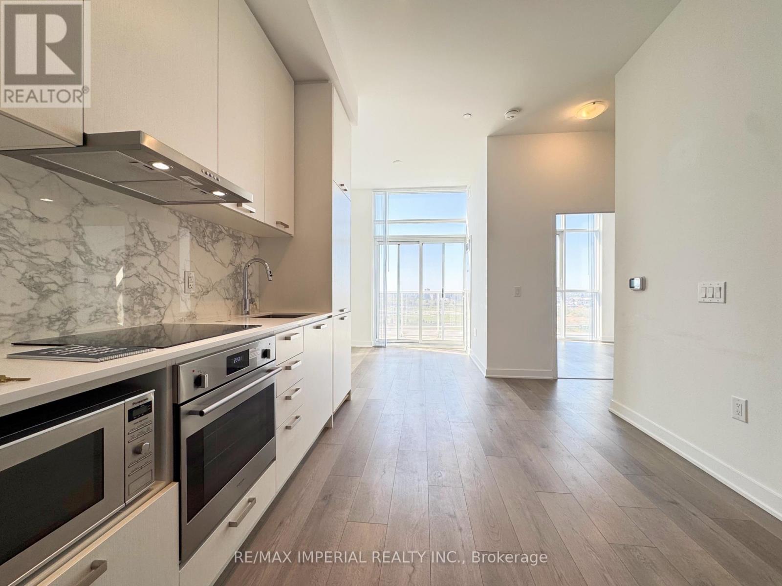 A kitchen with white cabinets and a marble countertop.