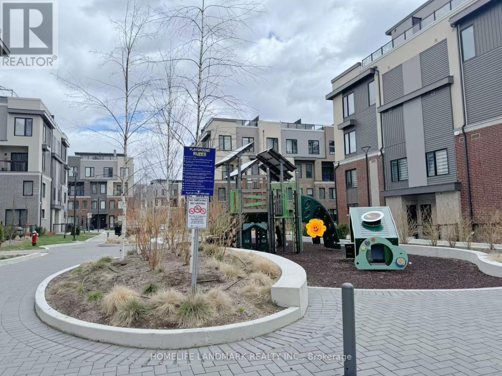 A sign in front of a building with a playground in the background.