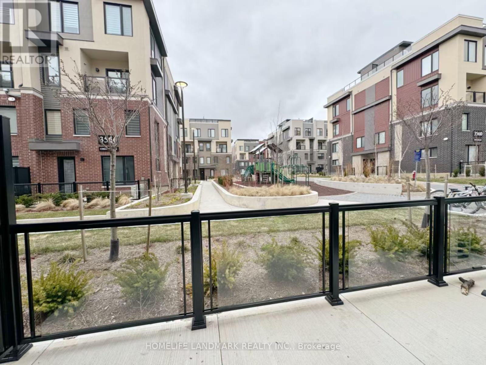 A view of a residential area with apartment buildings and a fenced walkway.
