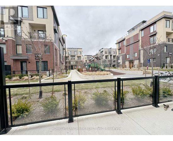 A view of a residential area with apartment buildings and a fenced walkway.