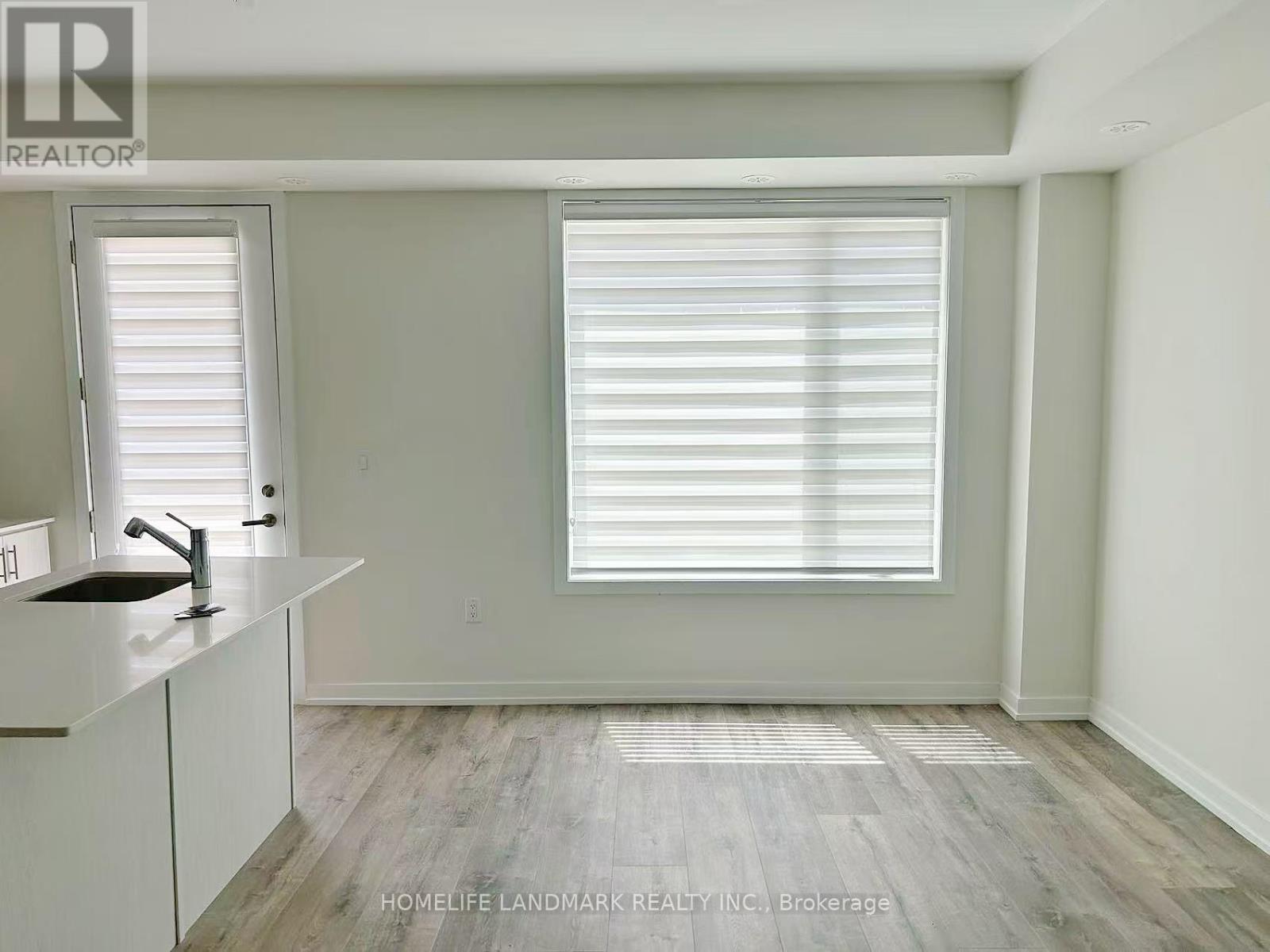 A room with a sink and a window with blinds.