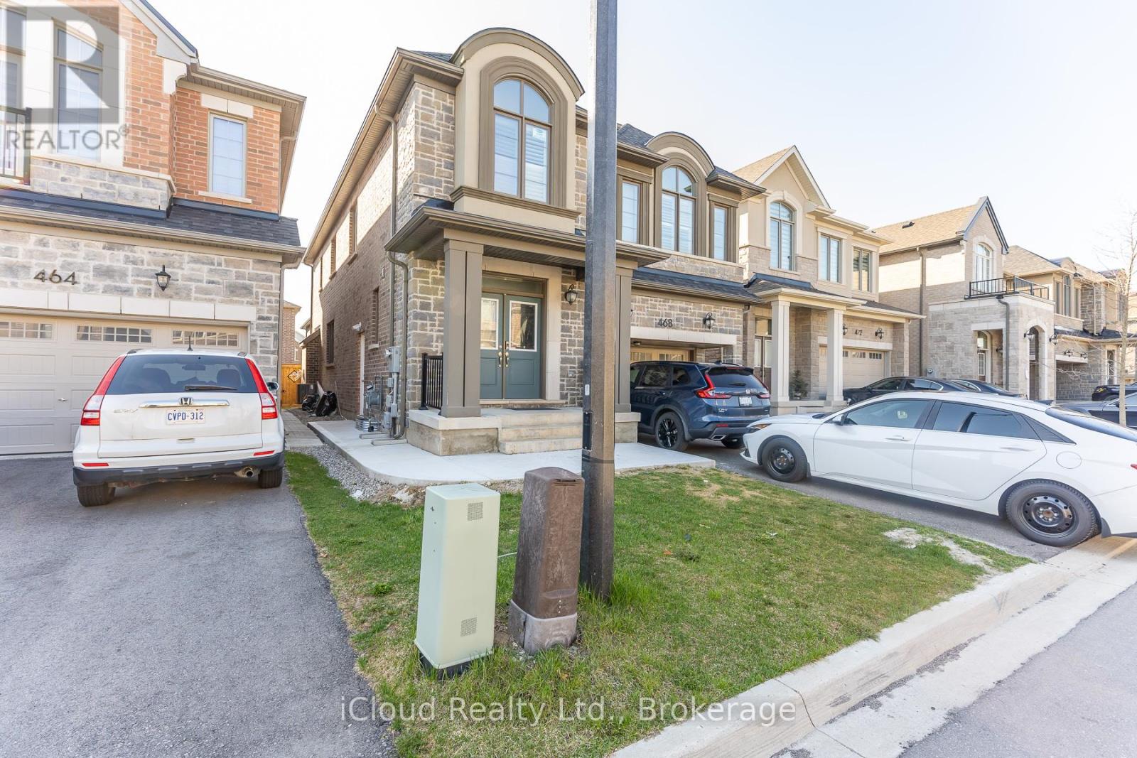 A row of houses with cars parked in front.