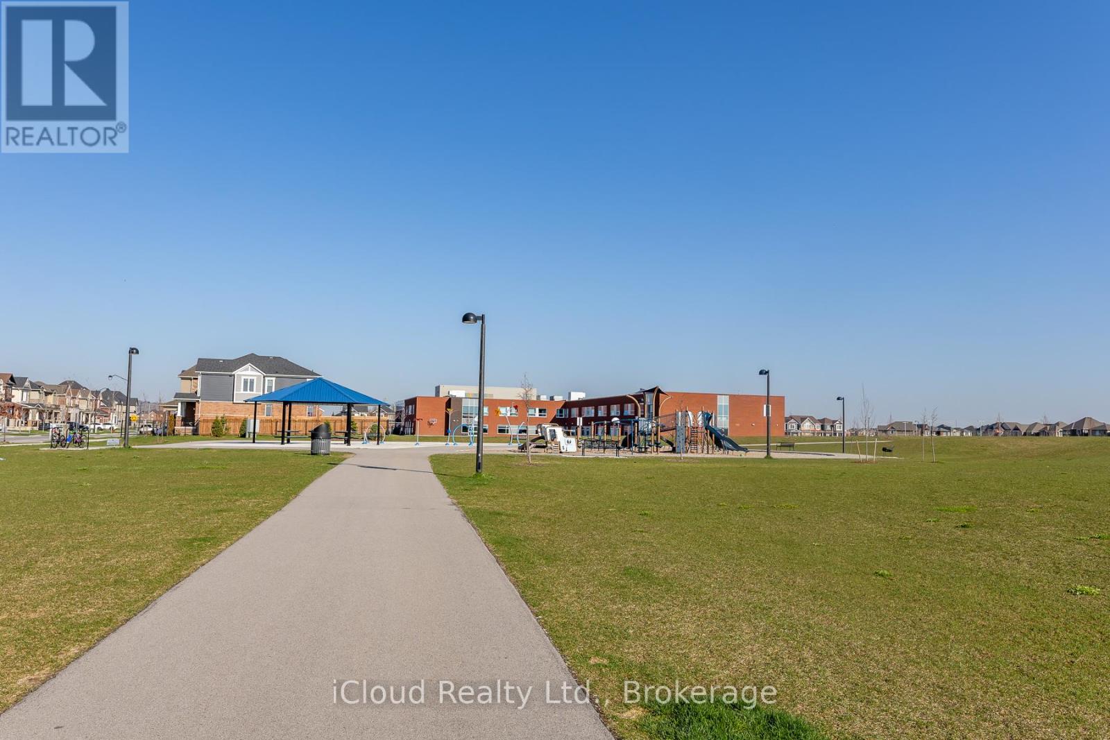 A park with a walking path in front of a building.