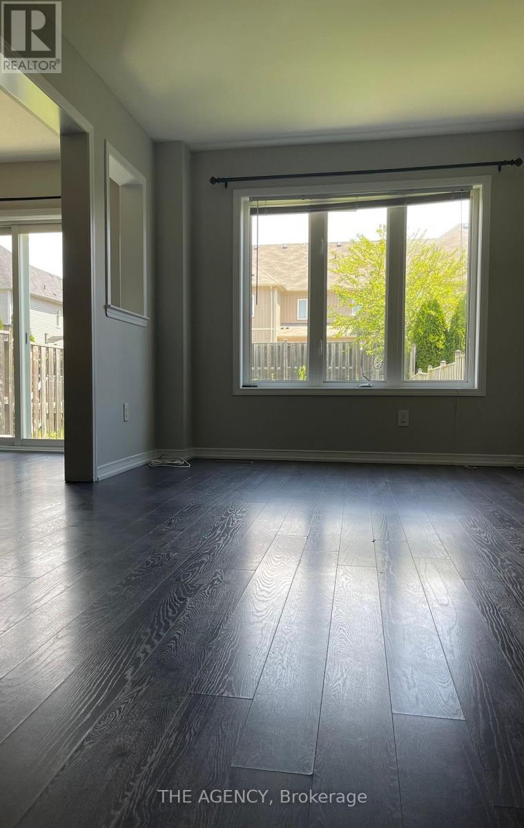 A room with a large window and wooden flooring.