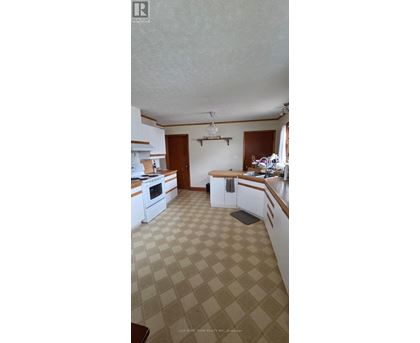 A kitchen with white cabinets and a checkered floor.