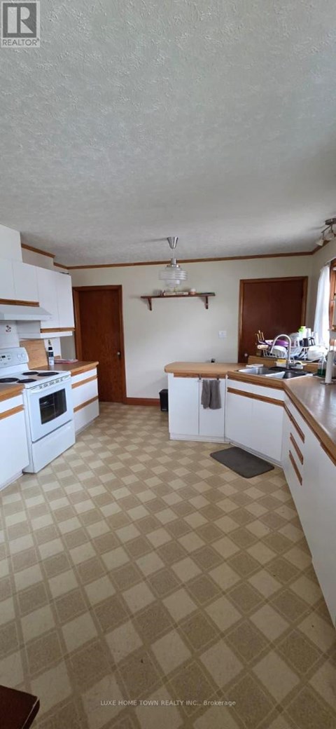 A kitchen with white cabinets and a checkered floor.