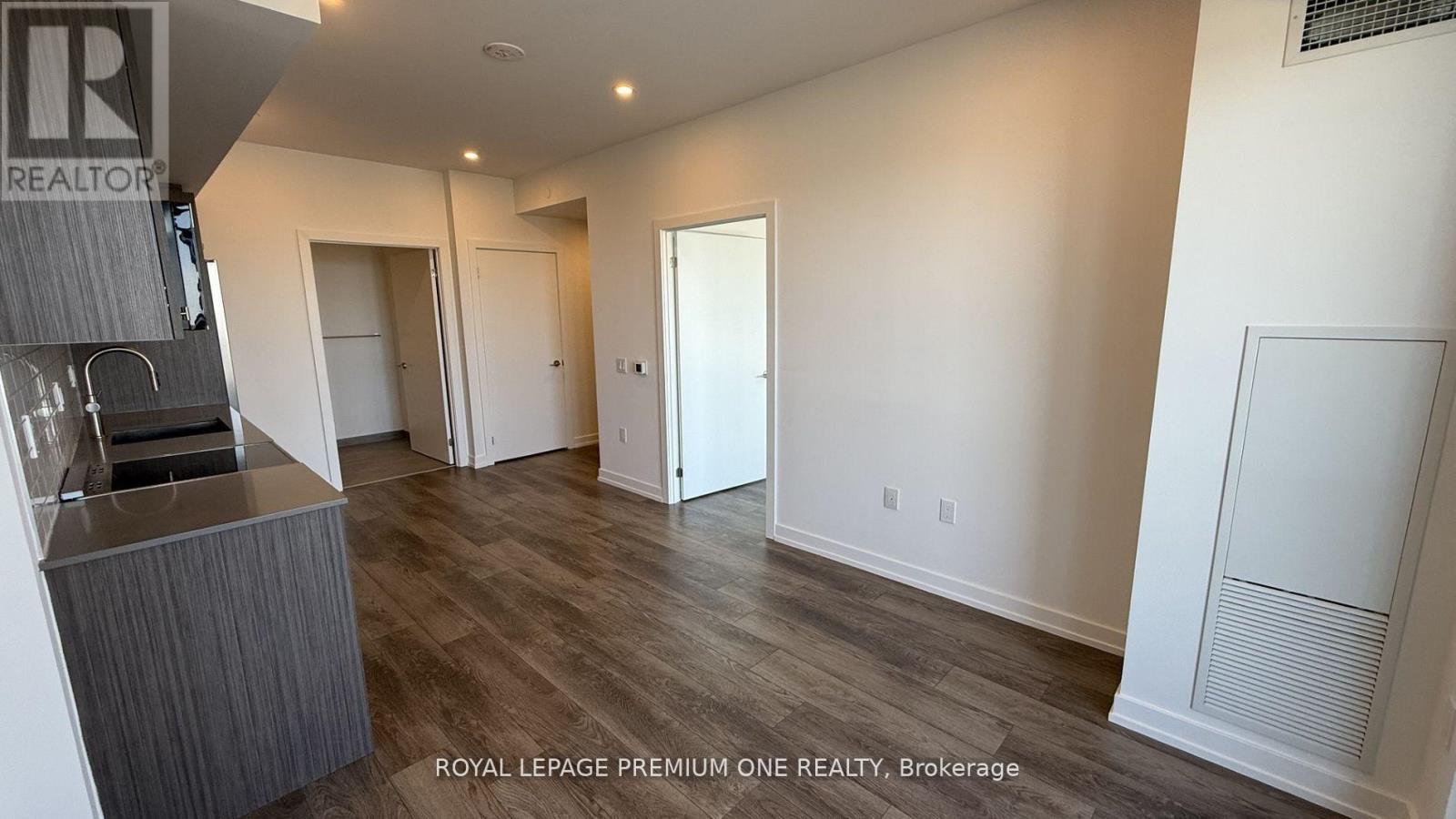 A spacious room with a bar area and a door leading to another room.