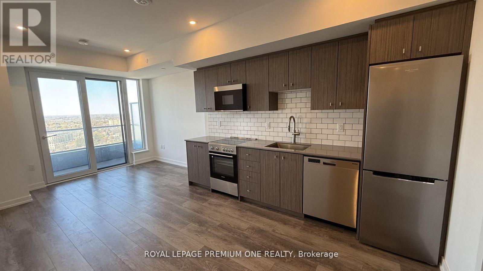 A modern kitchen with stainless steel appliances and wooden cabinets.