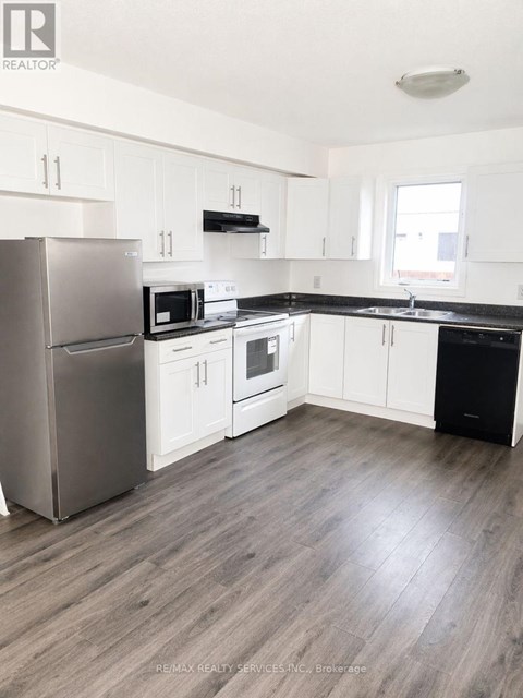 A kitchen with white cabinets and a stainless steel refrigerator.