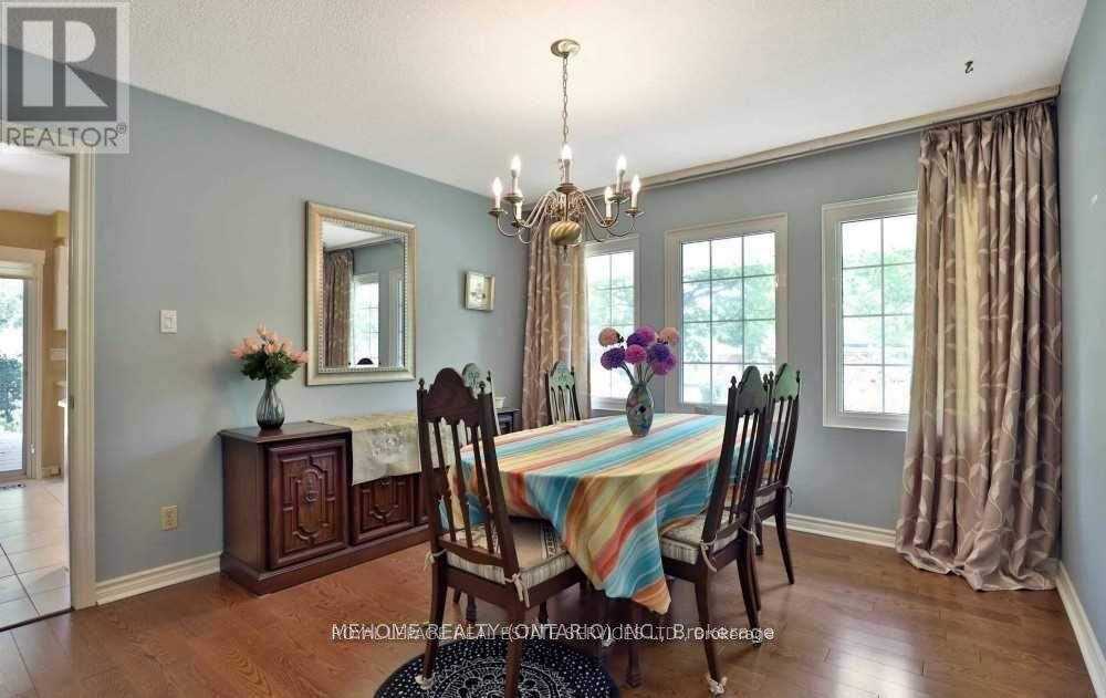 A dining room with a table set for four and a chandelier hanging from the ceiling.