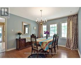 A dining room with a table set for four and a chandelier hanging from the ceiling.