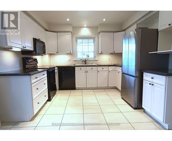 A kitchen with white cabinets and black appliances.