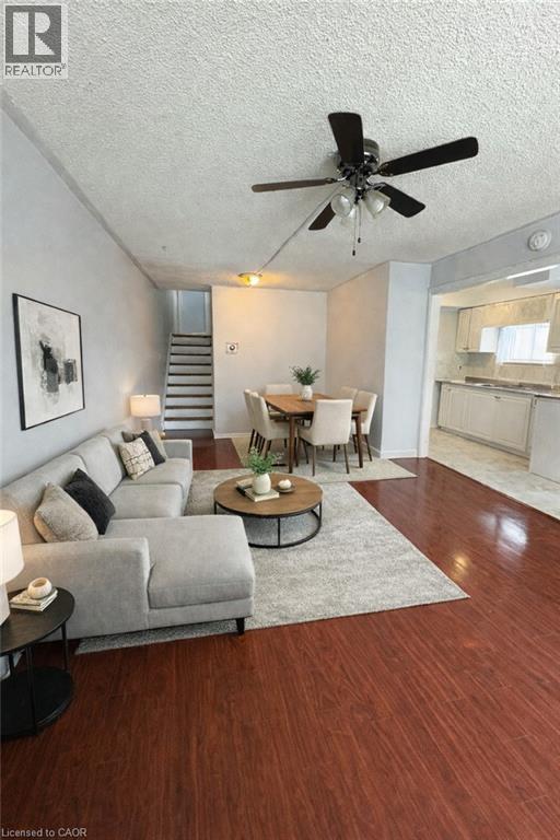 A living room with a grey couch, a coffee table, and a ceiling fan.