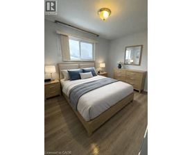 A bedroom with a bed, nightstands, and a window.