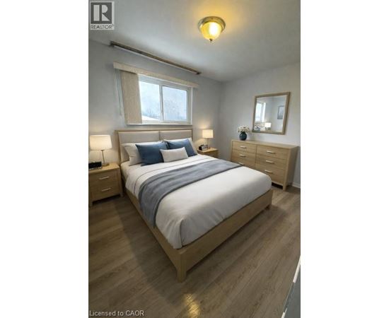 A bedroom with a bed, nightstands, and a window.
