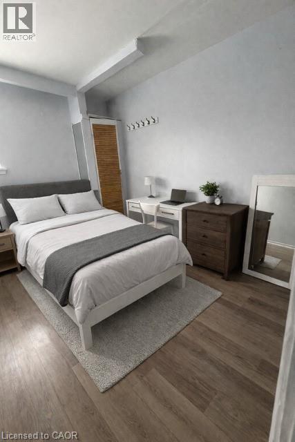 A bedroom with a large bed and a wooden nightstand.