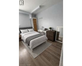 A bedroom with a large bed and a wooden nightstand.