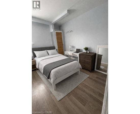 A bedroom with a large bed and a wooden nightstand.