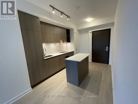 A modern kitchen with a wooden floor and a white countertop.