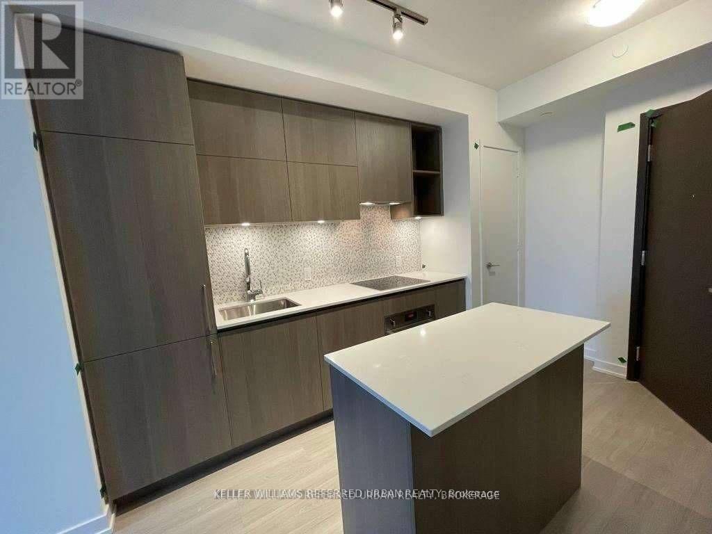 A modern kitchen with a white countertop and dark brown cabinets.