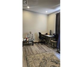 A room with a desk, chair, and computer setup.