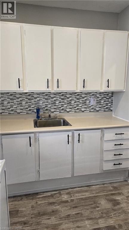 A kitchen with white cabinets and a sink.
