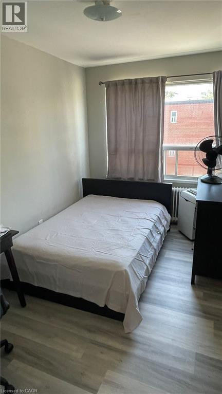 A bedroom with a bed, nightstand, and window.