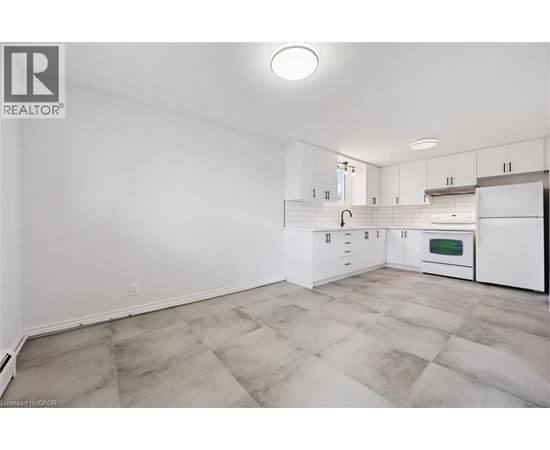 A kitchen with white cabinets and a tiled floor.