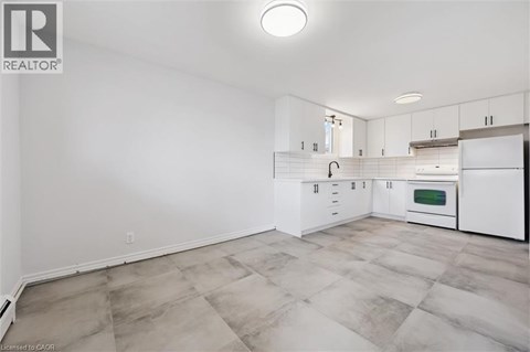 A kitchen with white cabinets and a tiled floor.